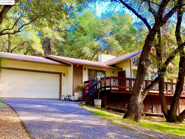 a front view of house with outdoor space and trees around