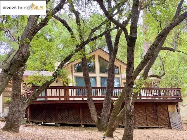 a front view of house with outdoor space and trees around
