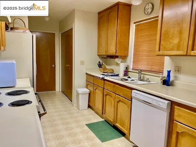 a kitchen with stainless steel appliances a sink a stove and a refrigerator
