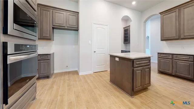 a kitchen with stainless steel appliances granite countertop a stove a sink and a microwave