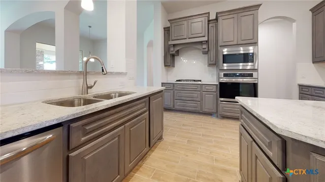 a kitchen with stainless steel appliances granite countertop a sink and cabinets