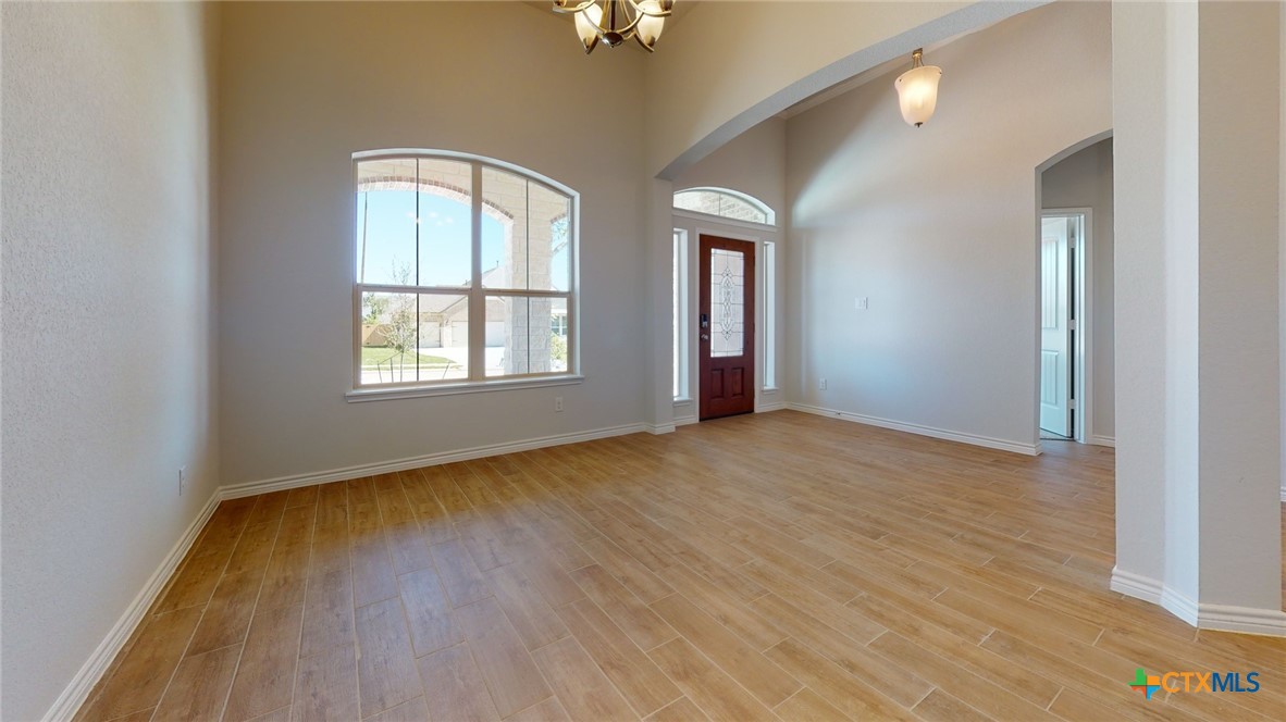 14089 Carsten Loop Salado, TX 76571 - Photo 10 of 17 an empty room with wooden floor and windows