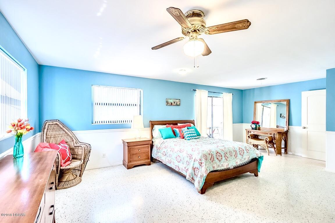 141 Beau Rivage Drive Ormond Beach, FL 32176 - Photo 12 of 34 a bedroom with a bed a window and a chandelier