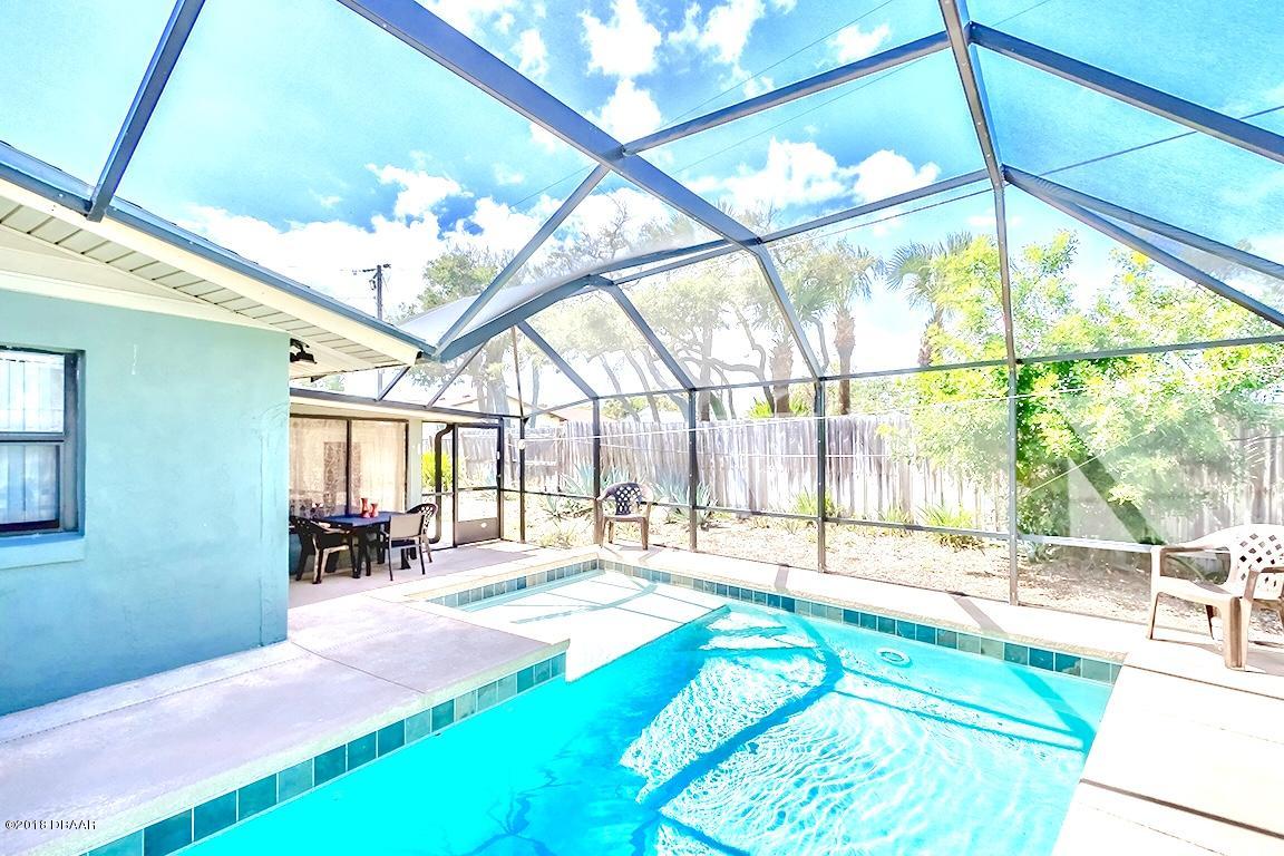 141 Beau Rivage Drive Ormond Beach, FL 32176 - Photo 24 of 34 a swimming pool with large glass windows and outdoor seating