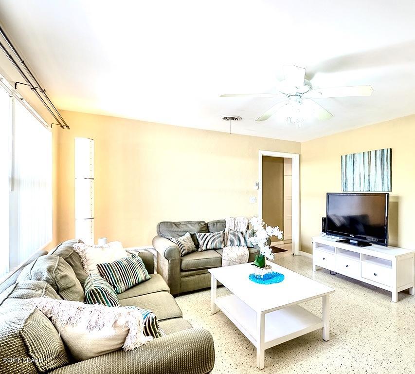 141 Beau Rivage Drive Ormond Beach, FL 32176 - Photo 6 of 34 a living room with furniture and a flat screen tv