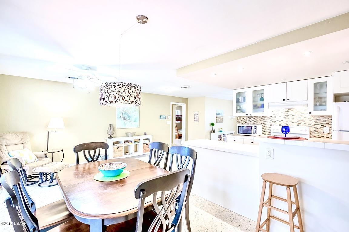 141 Beau Rivage Drive Ormond Beach, FL 32176 - Photo 9 of 34 a kitchen with kitchen island a dining table and chairs