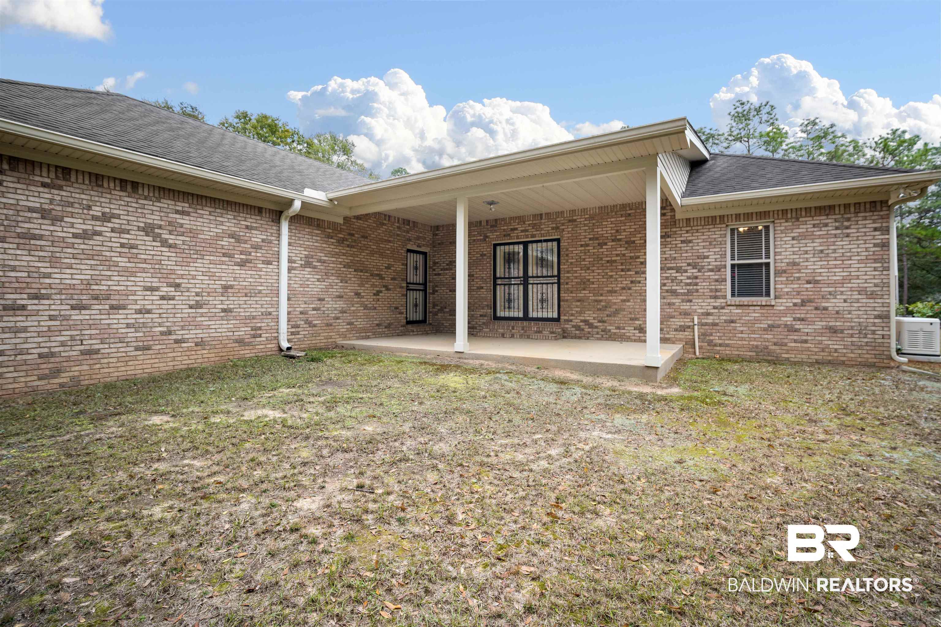 7419 Pake Road Saraland, AL 36571 - Photo 24 of 27 Back of property featuring a lawn and a patio area