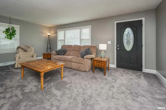 a living room with furniture a rug and a large window