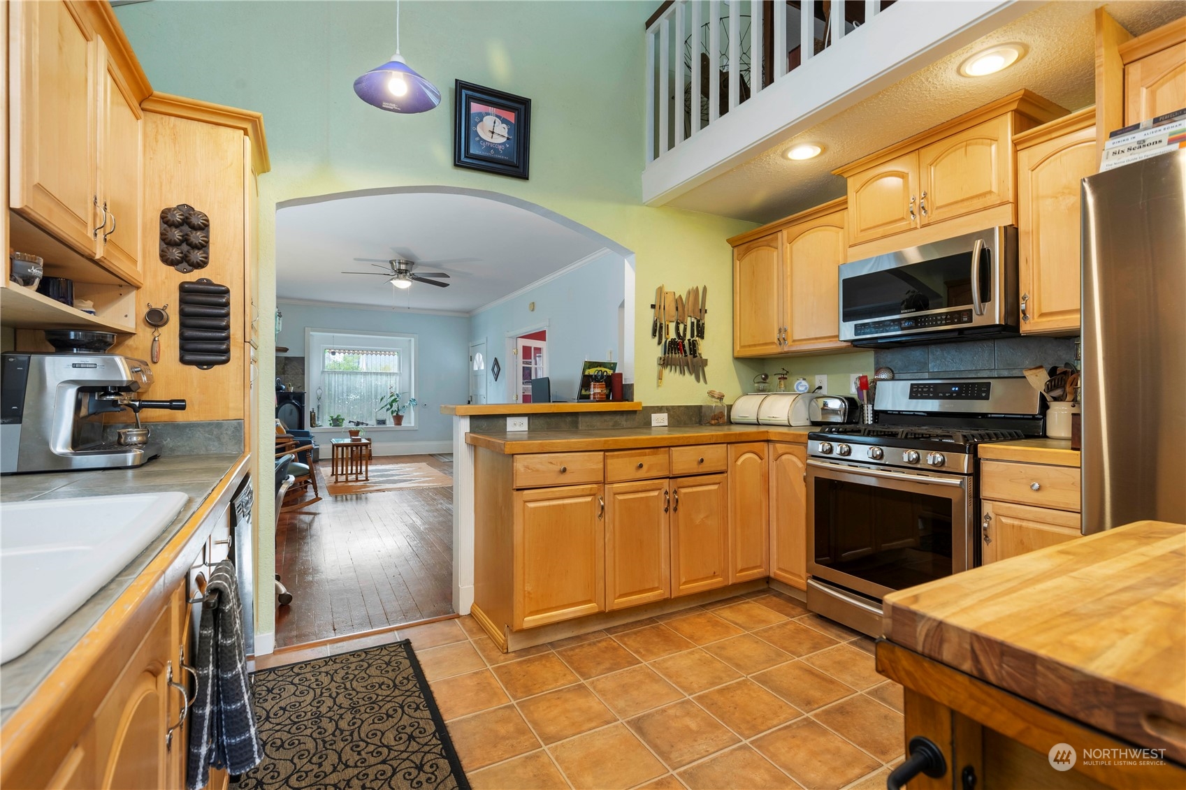 2812 19th Street Everett, WA 98201 - Photo 10 of 27 a kitchen with stainless steel appliances granite countertop a sink a stove top oven a chimney cabinets and a dining table