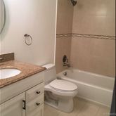 a bathroom with a granite countertop sink mirror vanity and toilet