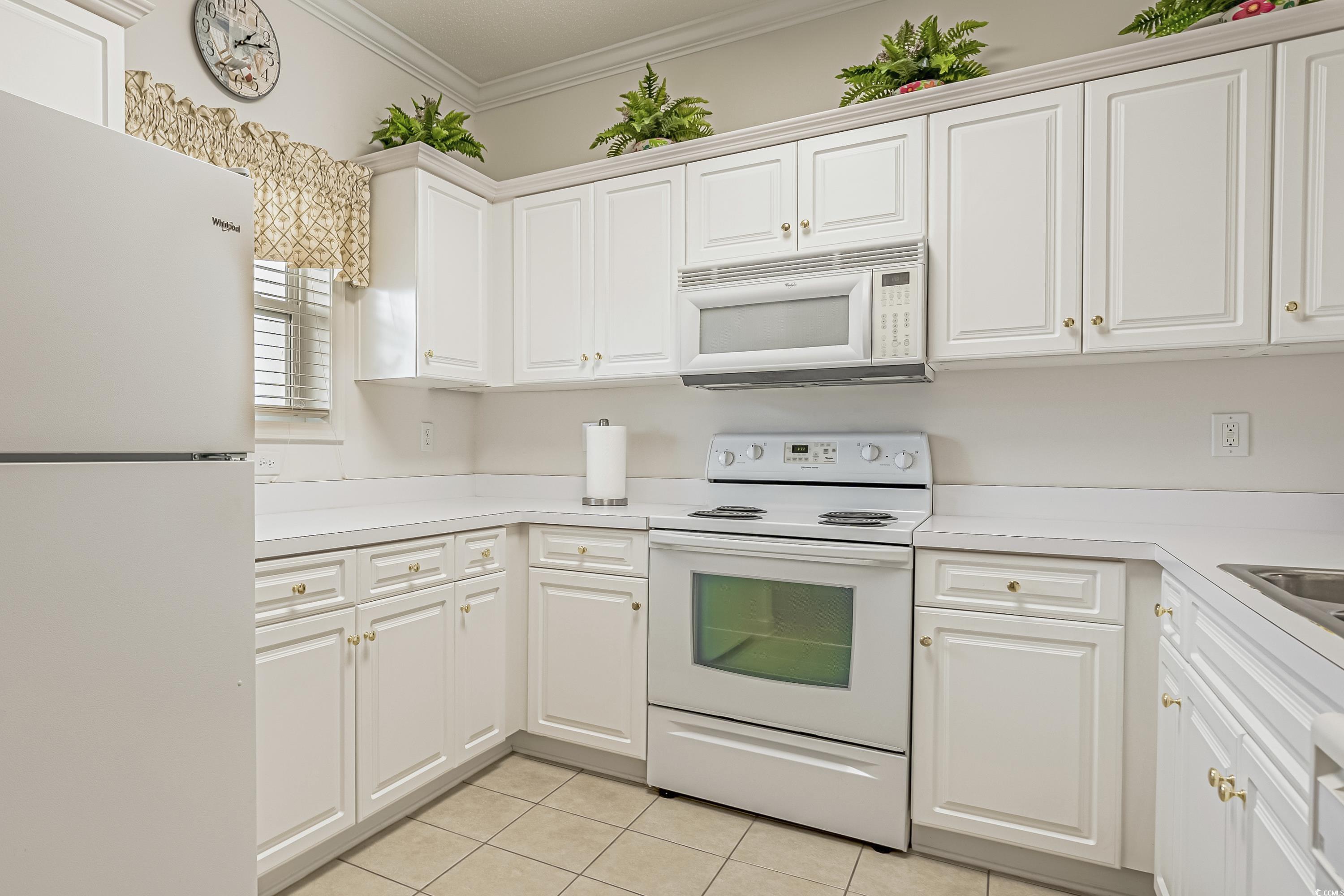 500 Wickham Drive, Unit HEATHERSTONE BUILDING 12 Myrtle Beach, SC 29579 - Photo 14 of 32 Kitchen featuring white appliances, ornamental molding, light countertops, light tile patterned floors, and white cabinets