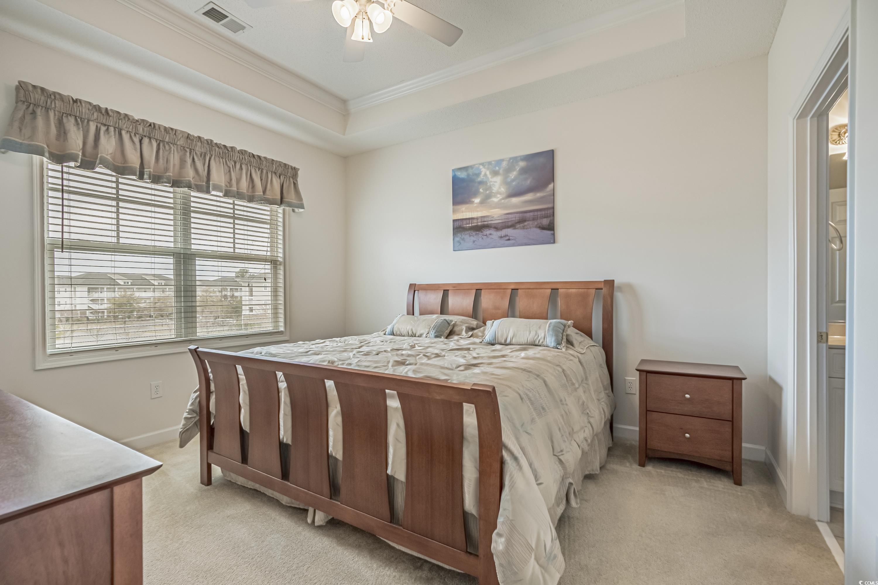 500 Wickham Drive, Unit HEATHERSTONE BUILDING 12 Myrtle Beach, SC 29579 - Photo 21 of 32 Bedroom with light carpet, a tray ceiling, crown molding, and ceiling fan