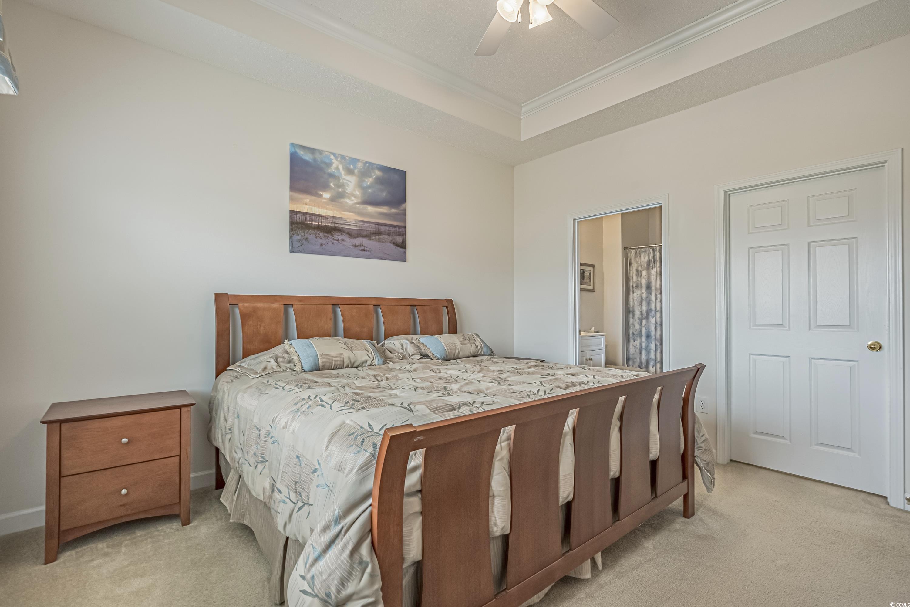 500 Wickham Drive, Unit HEATHERSTONE BUILDING 12 Myrtle Beach, SC 29579 - Photo 23 of 32 Bedroom featuring light colored carpet, ornamental molding, a tray ceiling, connected bathroom, and a ceiling fan