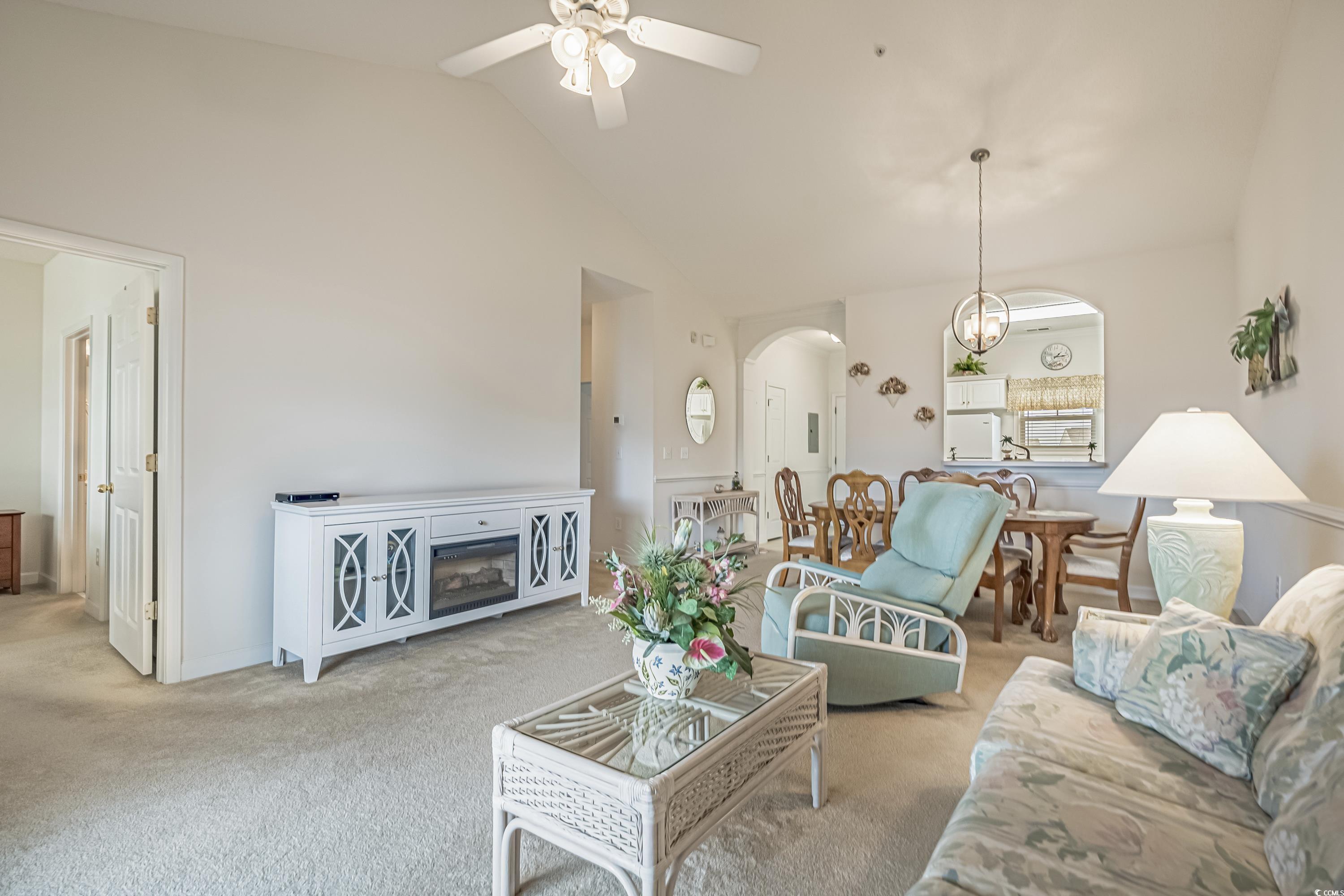 500 Wickham Drive, Unit HEATHERSTONE BUILDING 12 Myrtle Beach, SC 29579 - Photo 7 of 32 Living area with arched walkways, carpet, high vaulted ceiling, a ceiling fan, and a chandelier