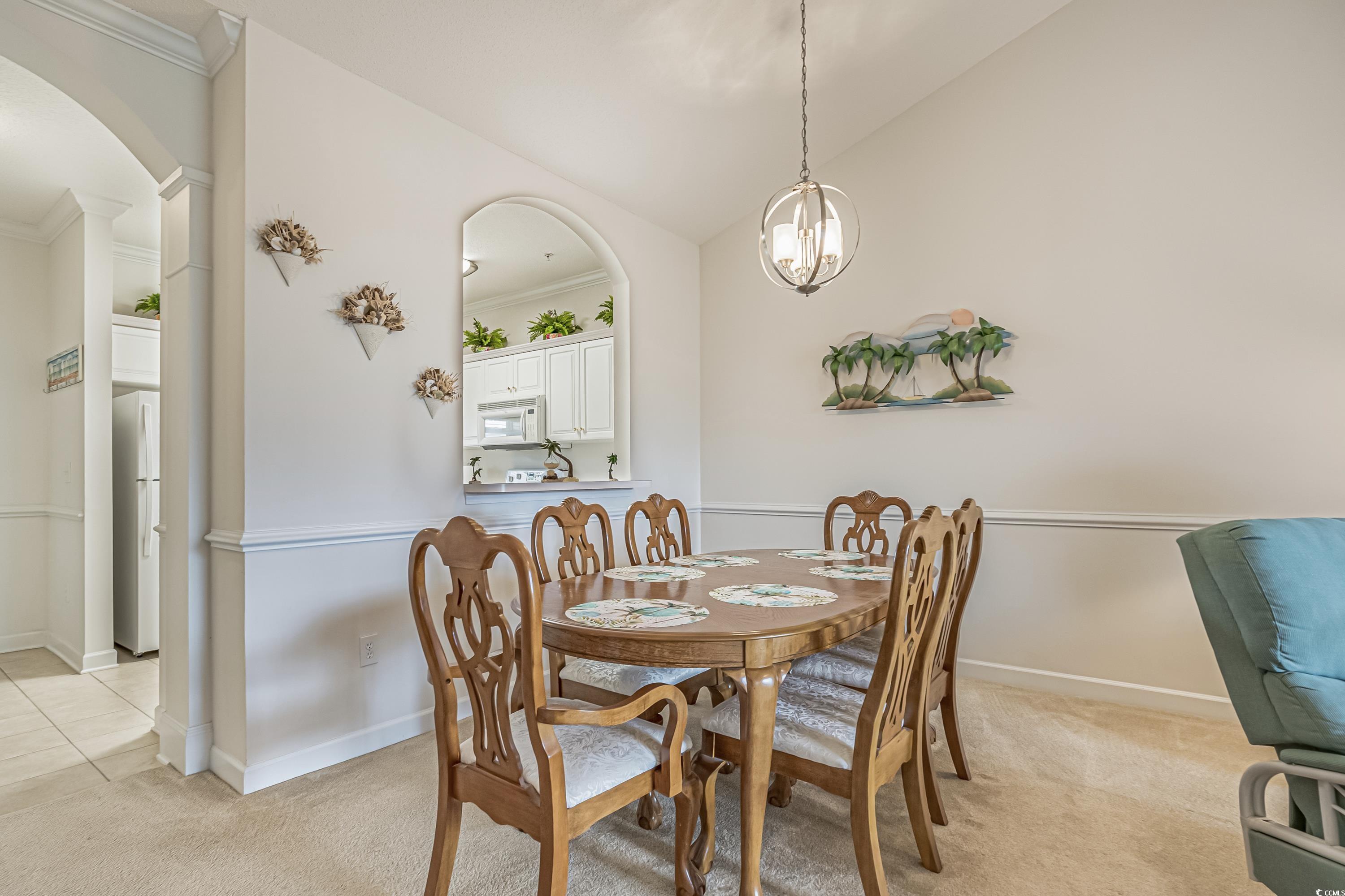 500 Wickham Drive, Unit HEATHERSTONE BUILDING 12 Myrtle Beach, SC 29579 - Photo 9 of 32 Dining room featuring light carpet, crown molding, arched walkways, and lofted ceiling