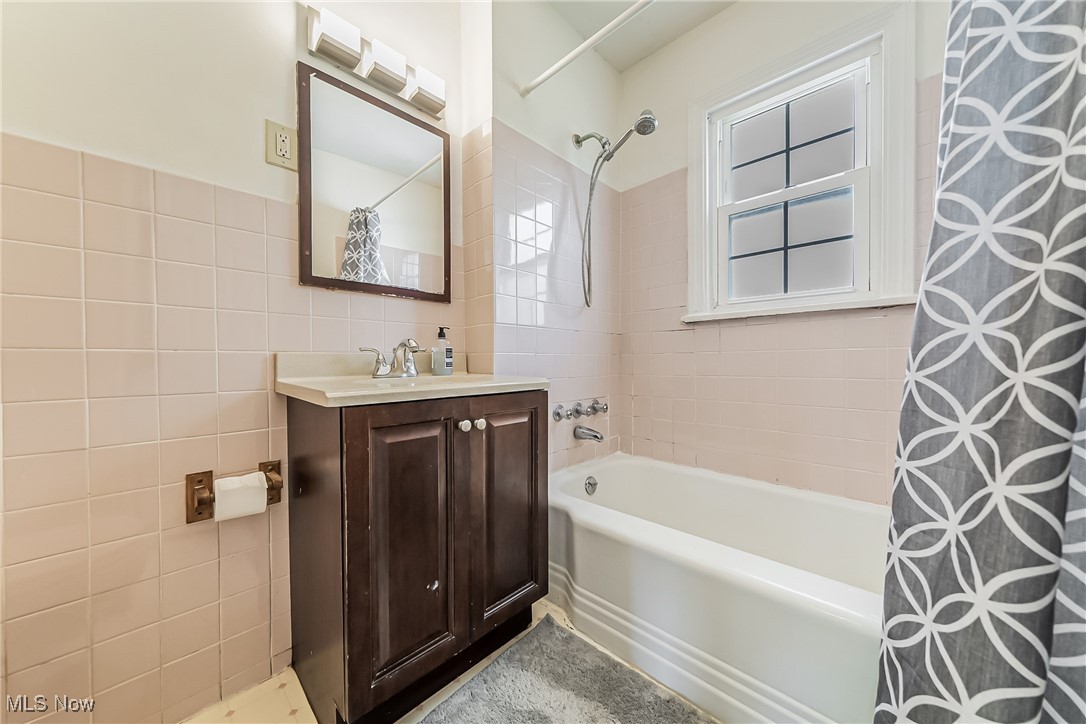 1607 Richmond Road Cleveland, OH 44124 - Photo 21 of 32 Bathroom featuring tile walls, vanity, and shower / bathtub combination with curtain