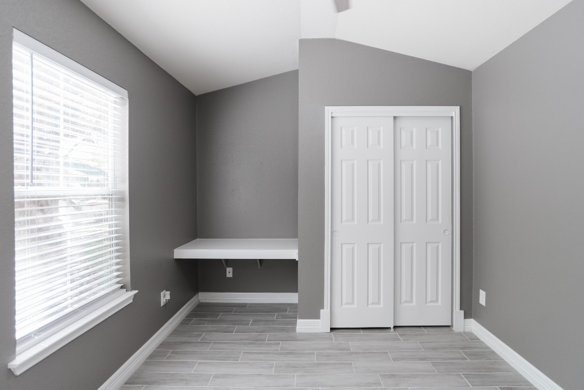 692 Scheel Kyle, TX 78640 - Photo 7 of 34 a view of an empty room with wooden floor and a window