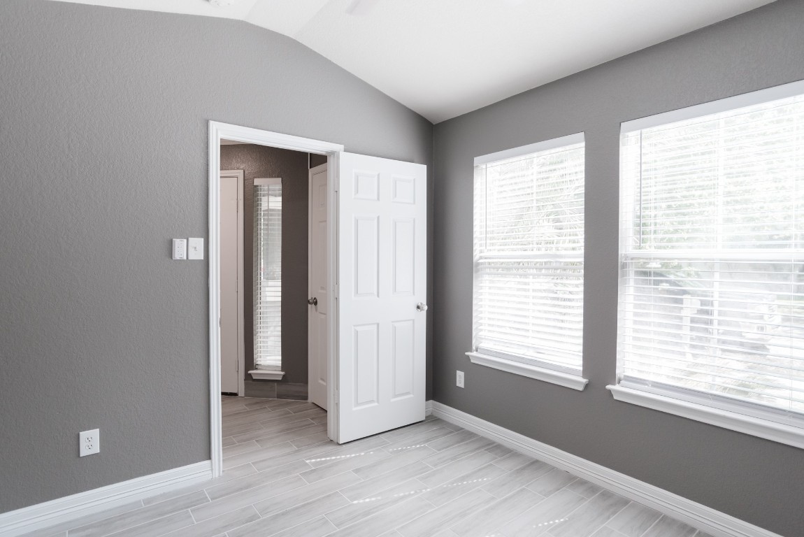 692 Scheel Kyle, TX 78640 - Photo 8 of 34 a view of an empty room with wooden floor and a window