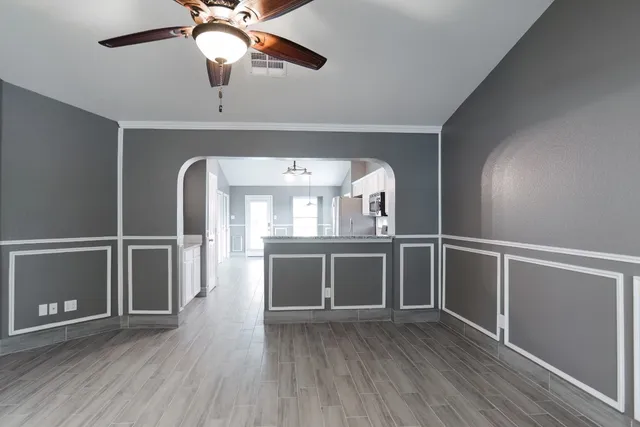 a view of an empty room with a window and wooden floor