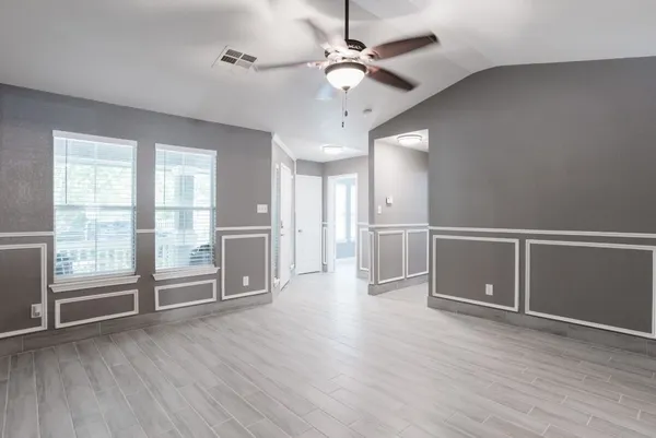 a view of an empty room with wooden floor