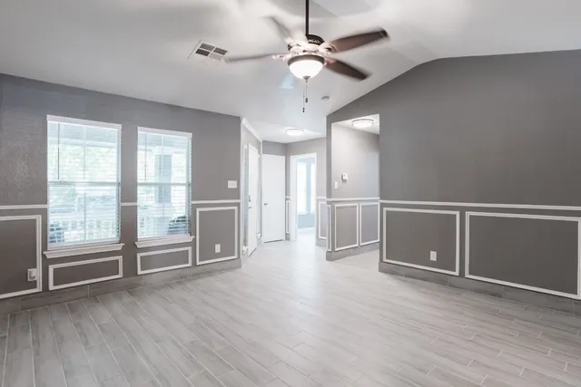 a view of an empty room with wooden floor