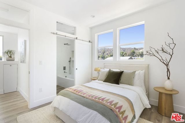 a bedroom with a bed and a potted plant on table