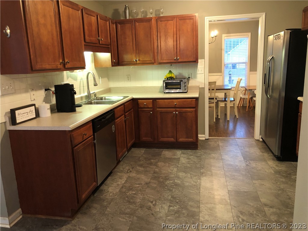 199 Falling Leaf Drive Raeford, NC 28376 - Photo 11 of 38 a kitchen with stainless steel appliances granite countertop a refrigerator sink and cabinets