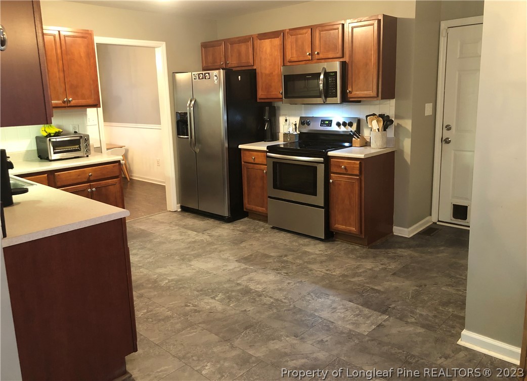 199 Falling Leaf Drive Raeford, NC 28376 - Photo 13 of 38 a kitchen with stainless steel appliances a refrigerator stove and sink