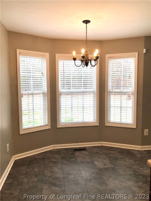 199 Falling Leaf Drive Raeford, NC 28376 - Photo 15 of 38 an empty room with chandelier and windows