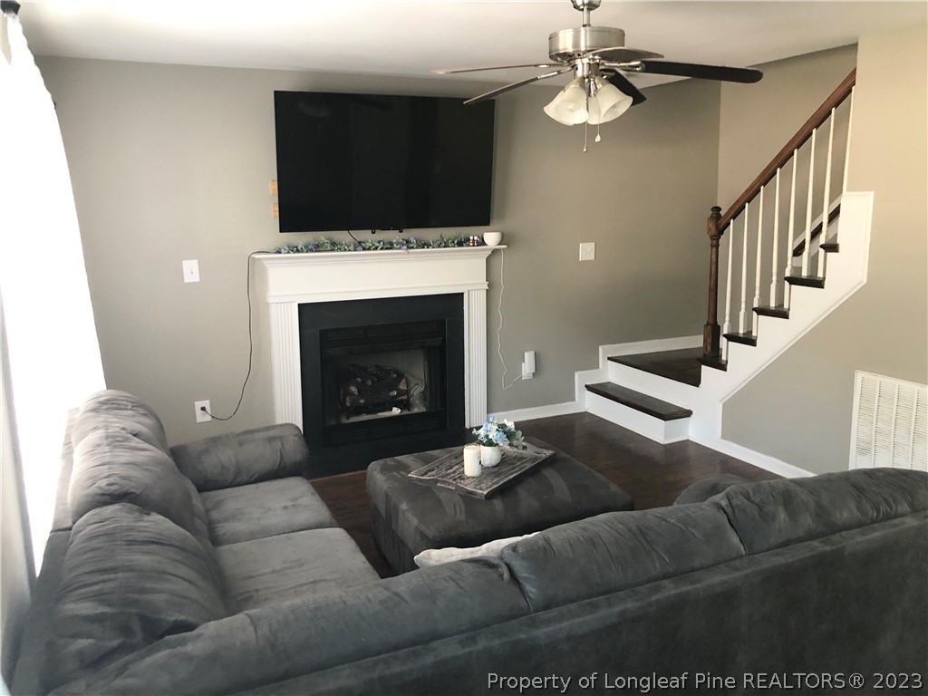 199 Falling Leaf Drive Raeford, NC 28376 - Photo 16 of 38 a living room with furniture a fireplace and a flat screen tv