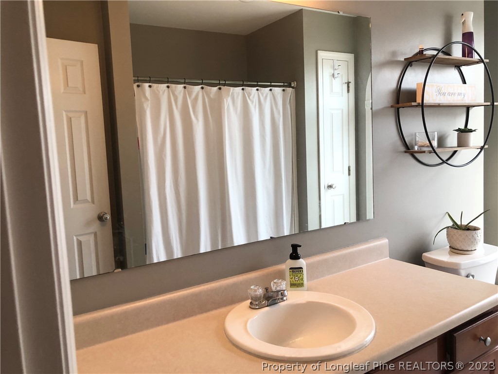 199 Falling Leaf Drive Raeford, NC 28376 - Photo 26 of 38 a bathroom with a sink and a mirror