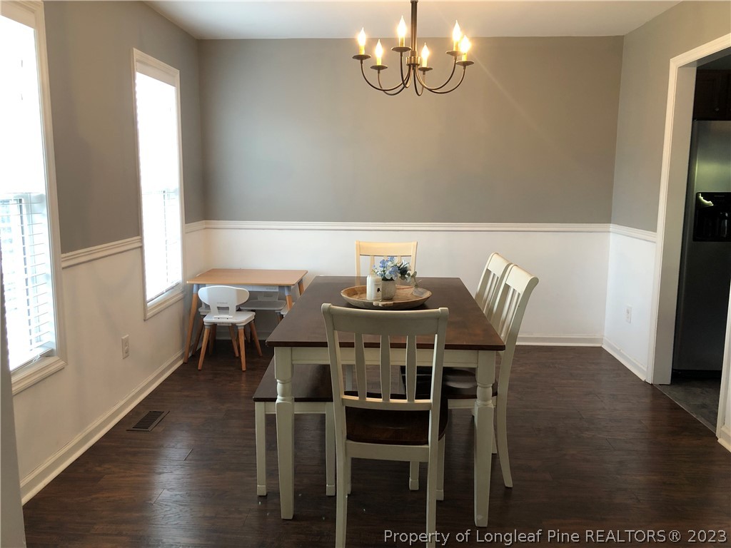 199 Falling Leaf Drive Raeford, NC 28376 - Photo 4 of 38 a view of a dining room with furniture wooden floor and chandelier