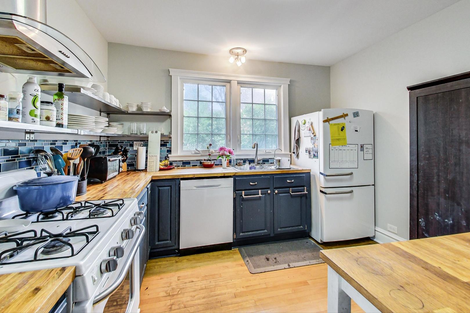 132 East Burlington Street Riverside, IL 60546 - Photo 11 of 38 a room with stainless steel appliances kitchen island granite countertop a sink a counter space and a window