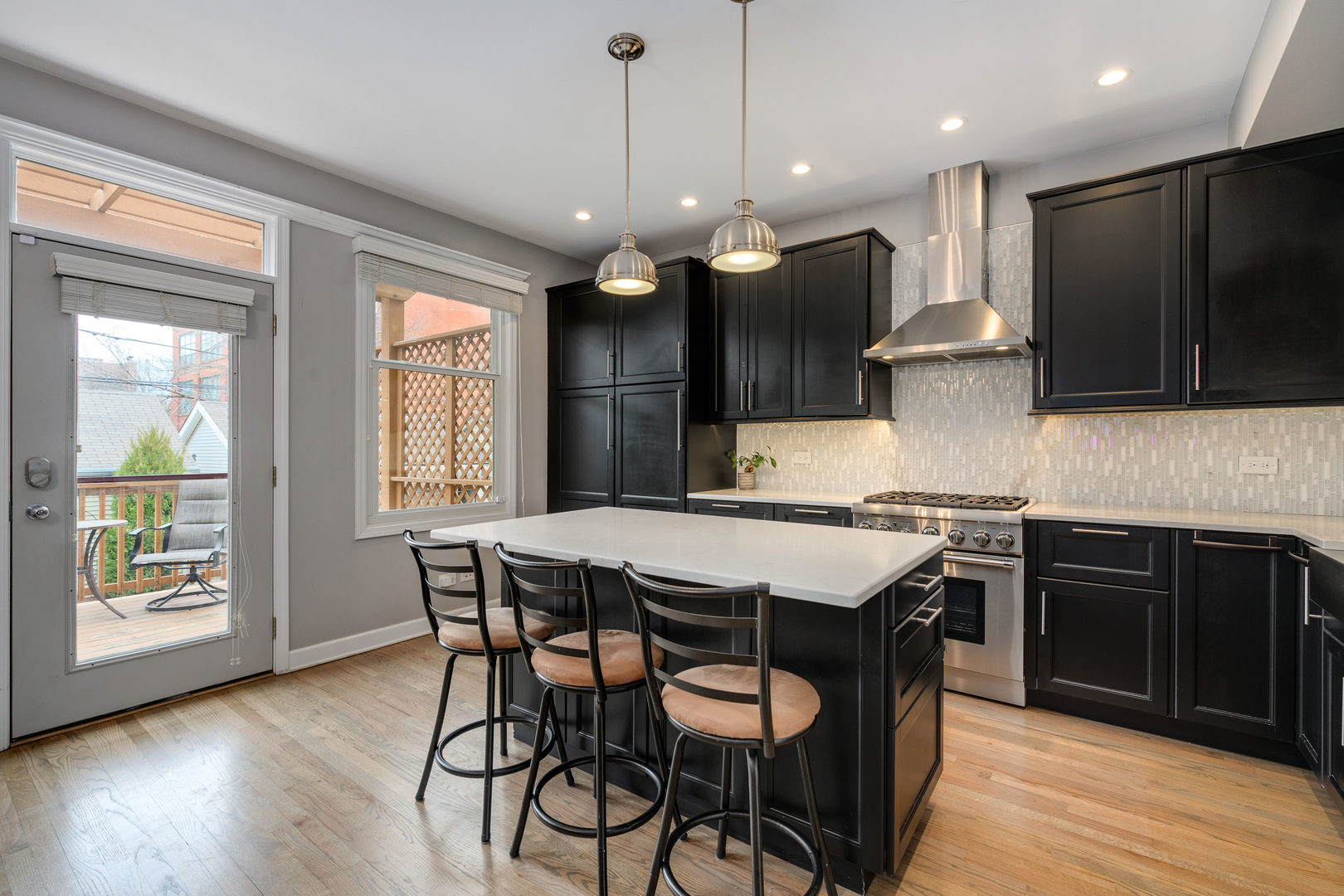 1718 West Huron Street Chicago, IL 60622 - Photo 8 of 33 a kitchen with stainless steel appliances granite countertop wooden floors stove and microwave