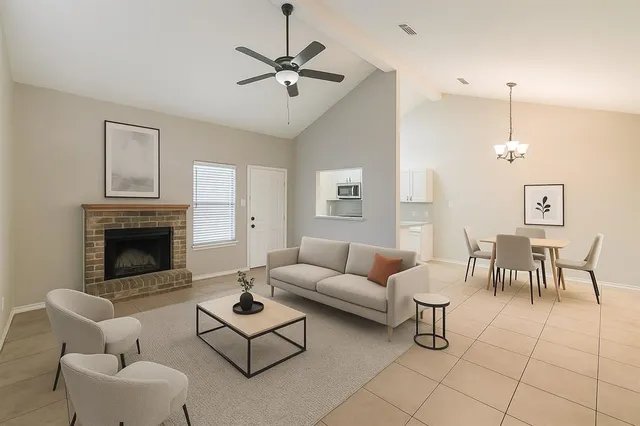 a living room with furniture a fireplace and a chandelier