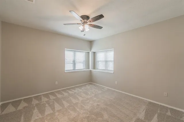 a view of an empty room and window and a kitchen