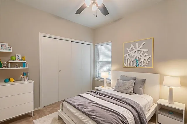 a bedroom with a bed and a lamp on dresser