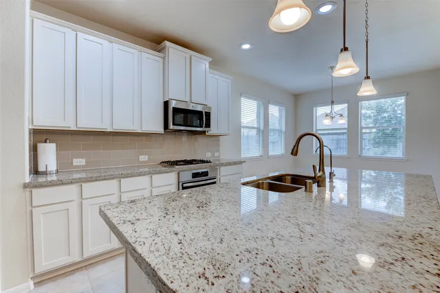 a kitchen with white cabinets and appliances