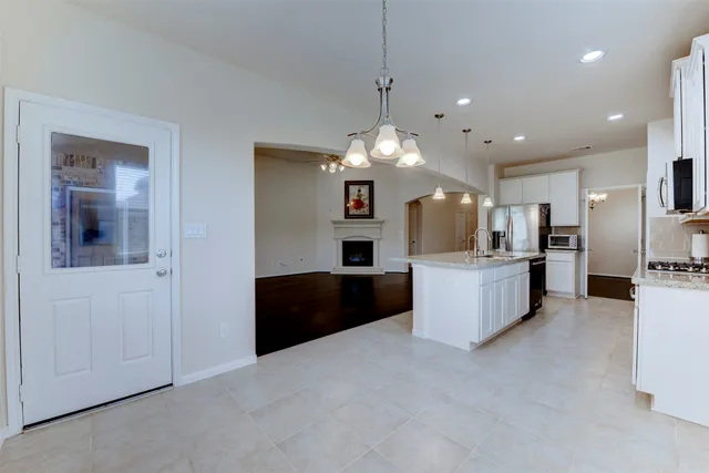 a large kitchen with a large counter top appliances and cabinets