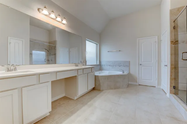 a large bathroom with a large tub double vanity sink and mirrors