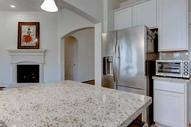 a kitchen with granite countertop a refrigerator and a sink