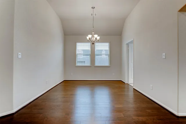 a view of a room with wooden floor and chandelier