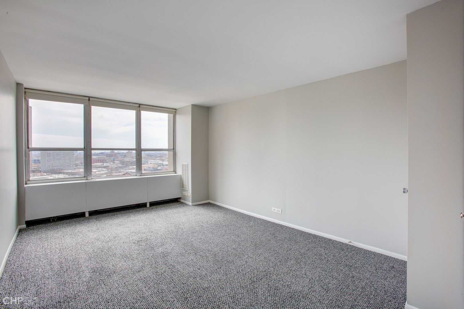655 West Irving Park Road, Unit 1703 Chicago, IL 60613 - Photo 3 of 15 an empty room with large windows