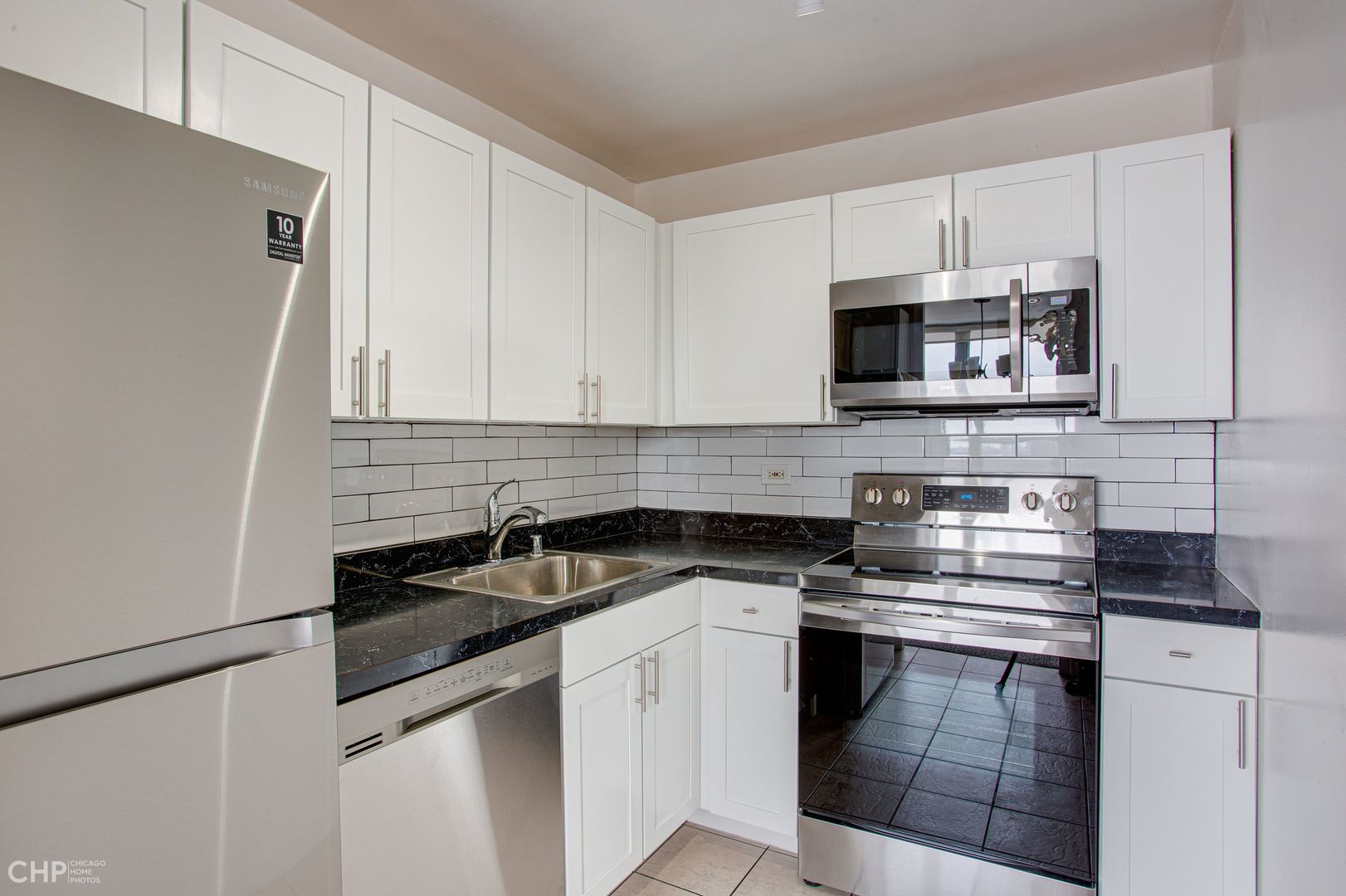 655 West Irving Park Road, Unit 1703 Chicago, IL 60613 - Photo 5 of 15 a kitchen with granite countertop white cabinets and black appliances