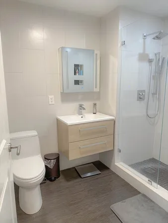 a bathroom with a sink a toilet and shower