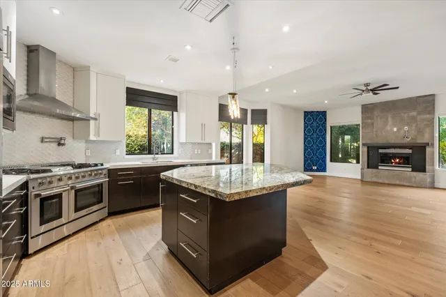 a kitchen with granite countertop counter top space a sink stainless steel appliances and windows