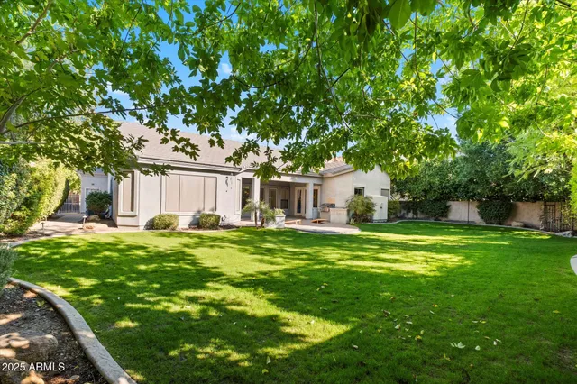 a front view of a house with a garden and trees
