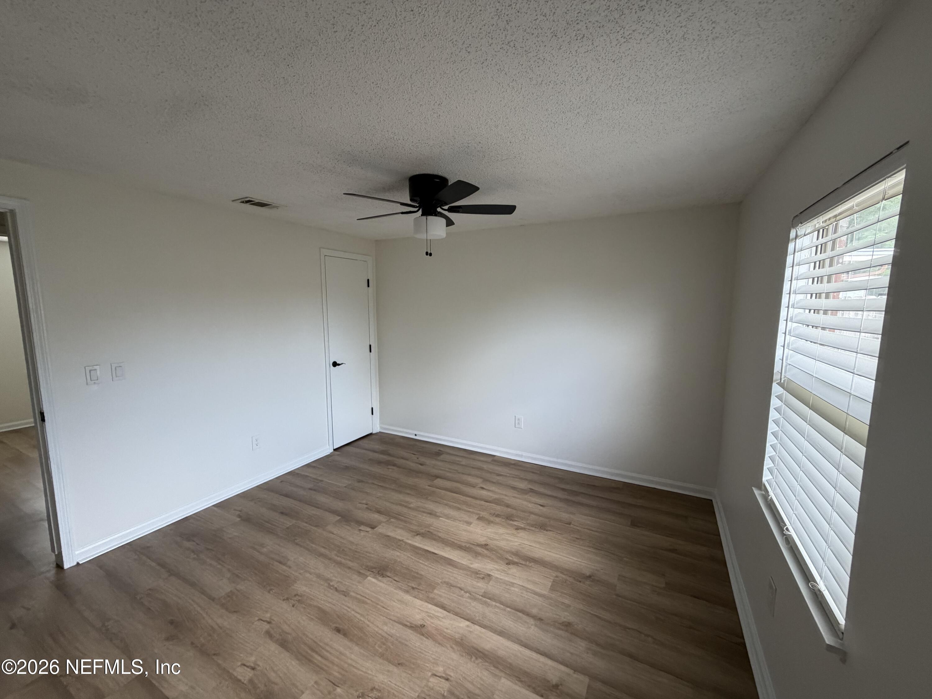 7539 Walden Road Jacksonville, FL 32244 - Photo 8 of 18 wooden floor in an empty room with a window