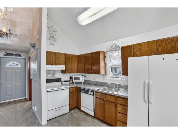 a kitchen with a sink a refrigerator and cabinets