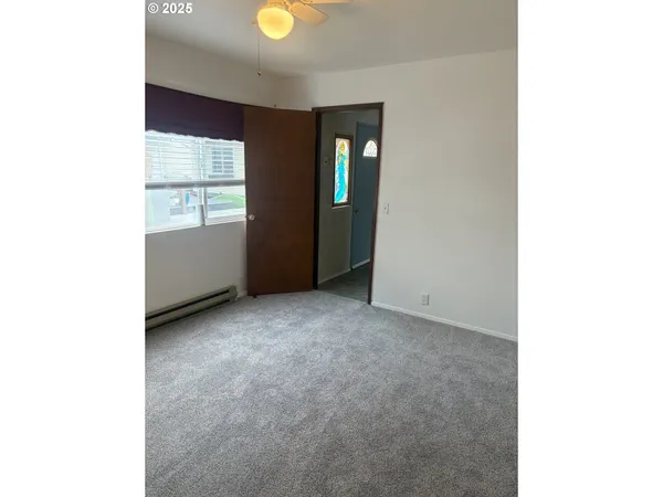 a view of an empty room with window and bathroom